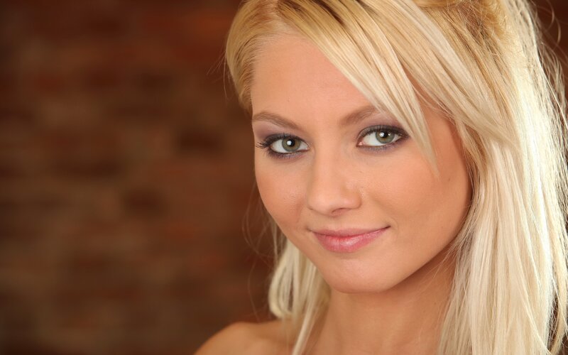 Blonde Woman Smiling — Neutral, Photograph, Bricks