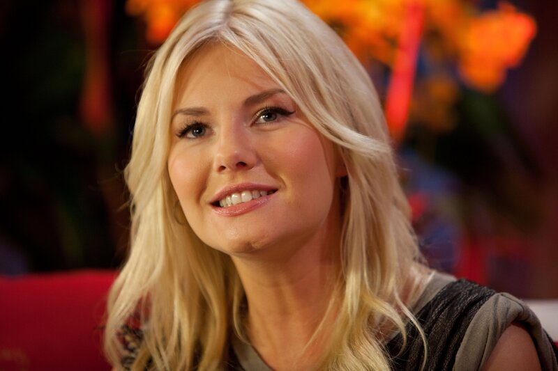 Blonde woman smiling on red couch