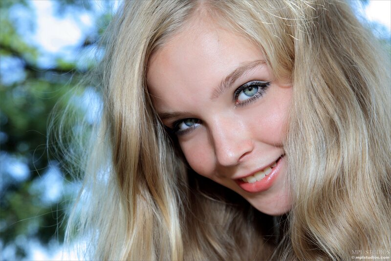 blonde woman smiling outdoors