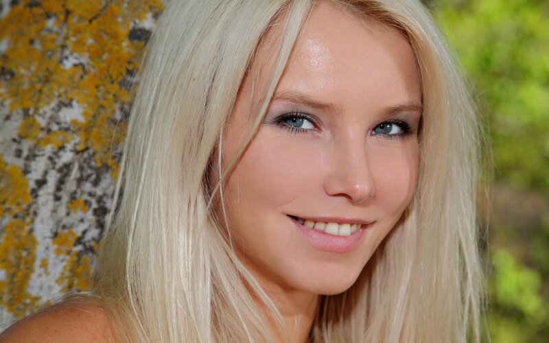 blonde woman smiling outdoors