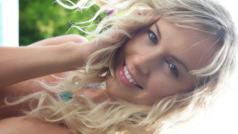 blonde woman smiling outdoors
