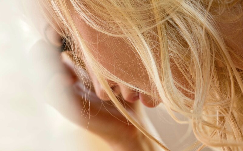 blonde woman with hair covering face