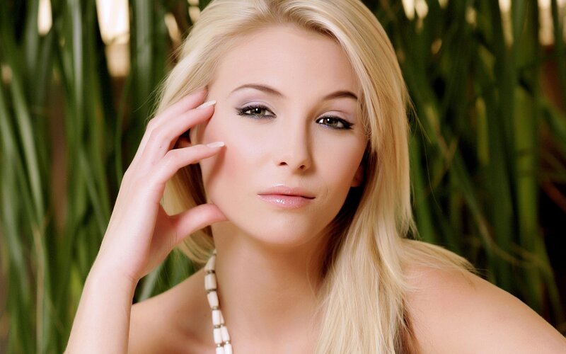 blonde woman with hand on face