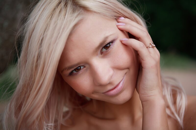 blonde woman with hand on face