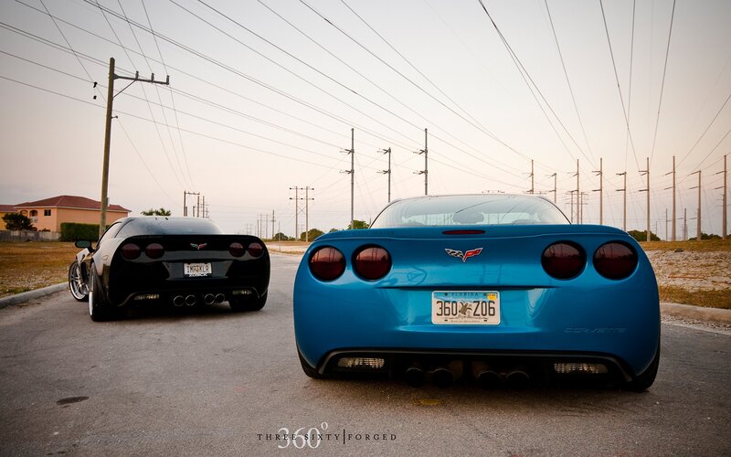 Blue and black Corvettes on a road