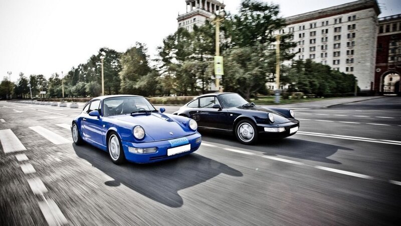 Blue and black Porsche cars driving