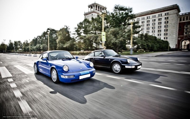 Blue and black Porsche cars on road
