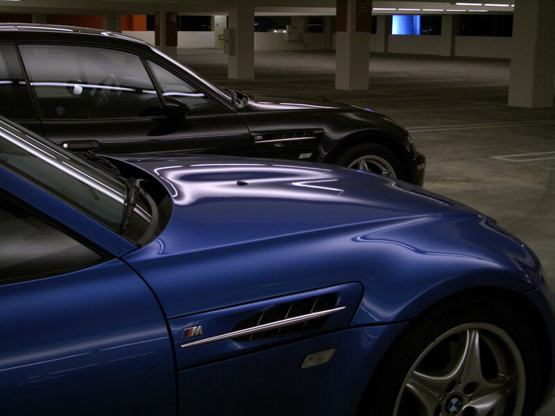 Blue and black sports cars in garage