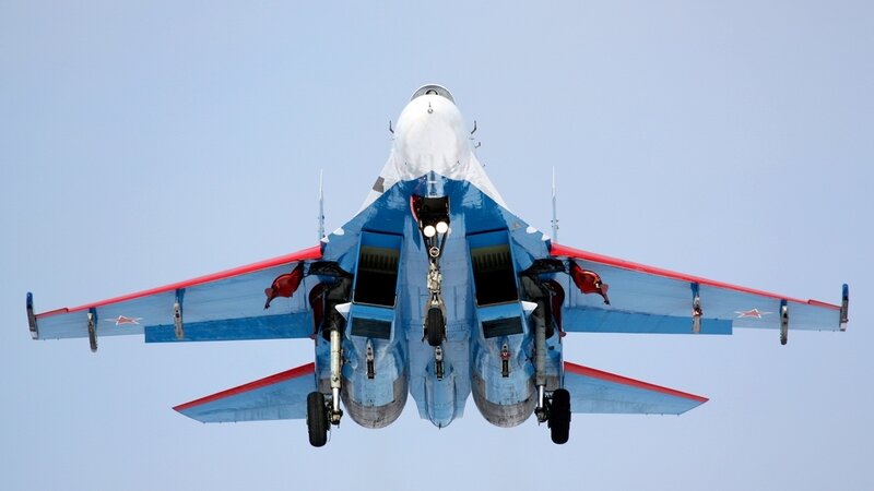 Blue and red fighter jet in flight