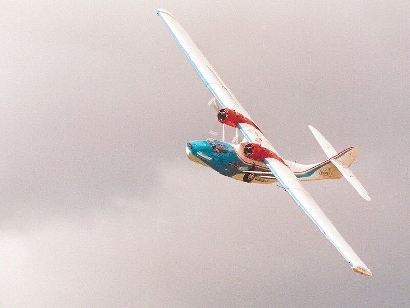 blue and red seaplane in flight