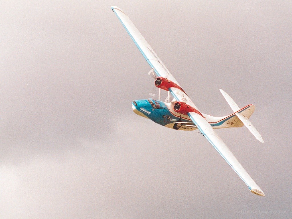 blue and red seaplane in flight