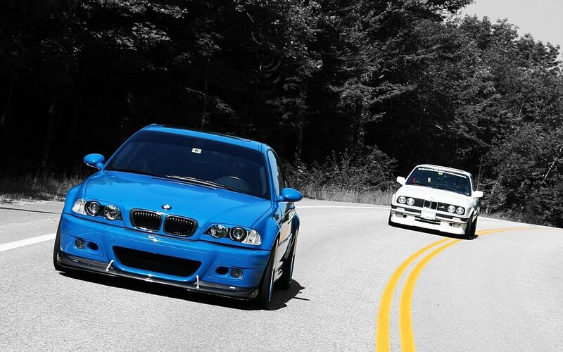 Blue and white BMWs on a road