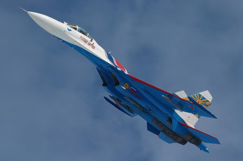 Blue and white fighter jet in flight