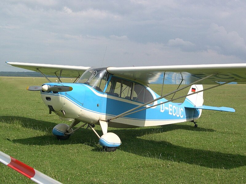 Blue and white light aircraft on grass