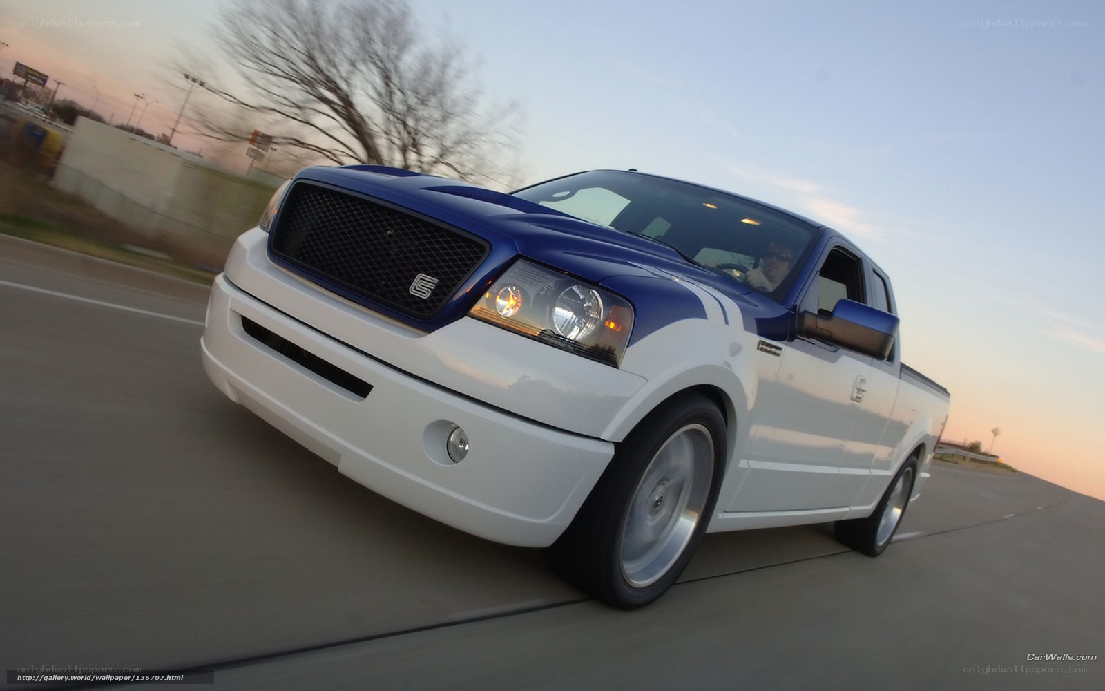 blue and white pickup truck in motion