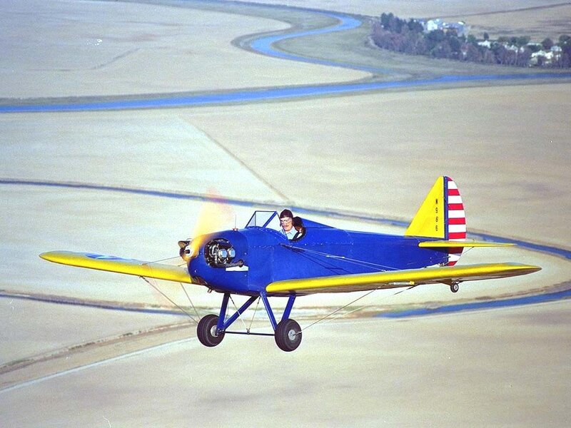 Blue and yellow biplane in flight