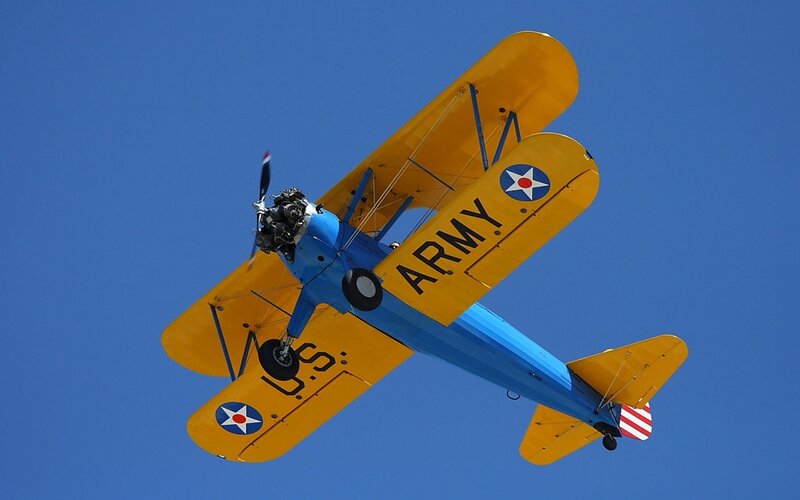 Blue and yellow biplane in flight