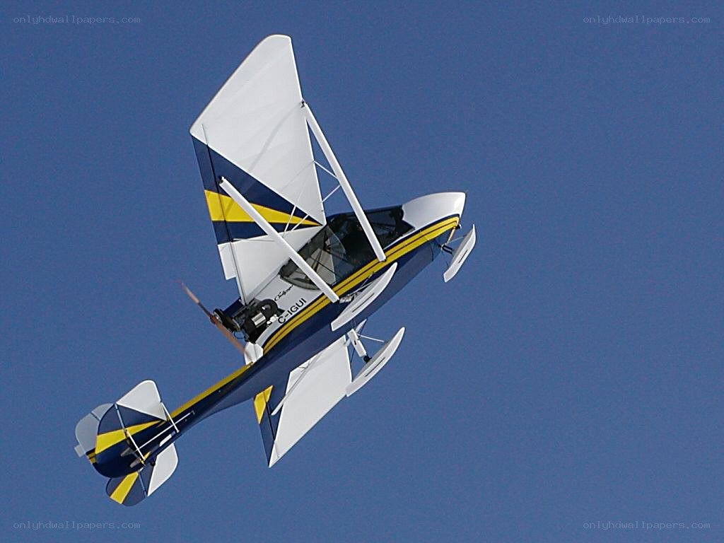 blue and yellow biplane in flight