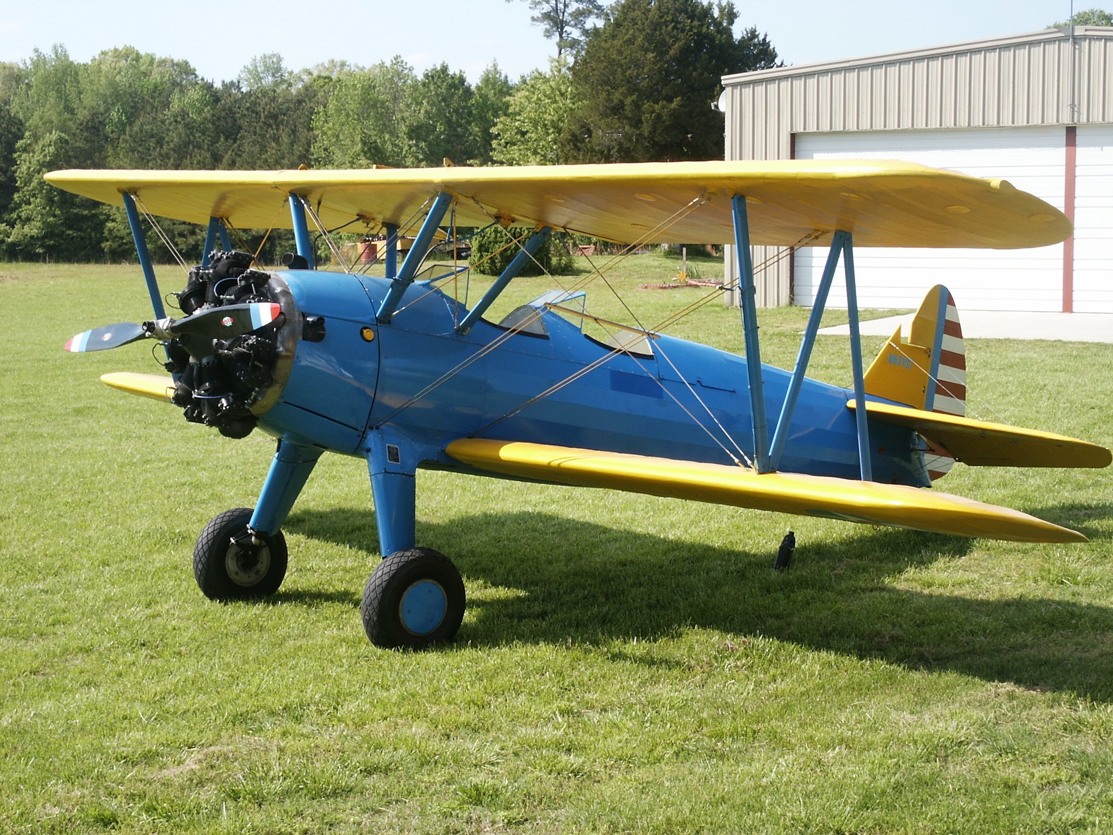 blue and yellow biplane on grass
