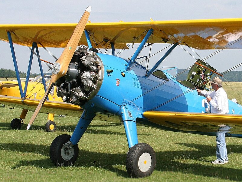 Blue and yellow biplane on grass