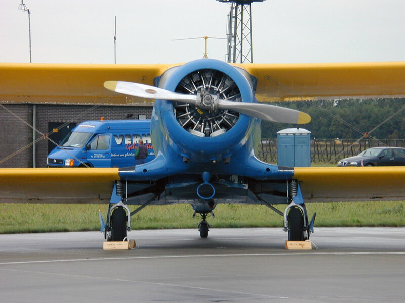 blue and yellow biplane on tarmac