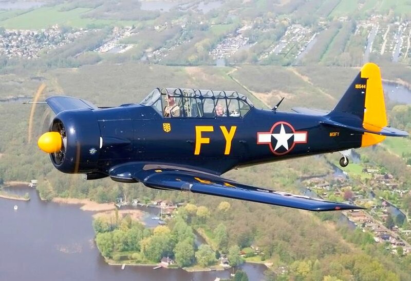 Blue and yellow military aircraft in flight