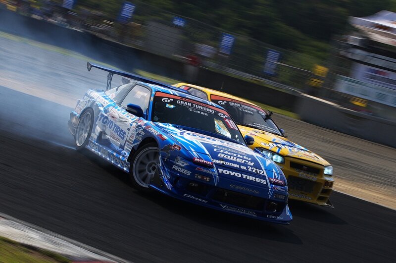 Blue and yellow race cars drifting