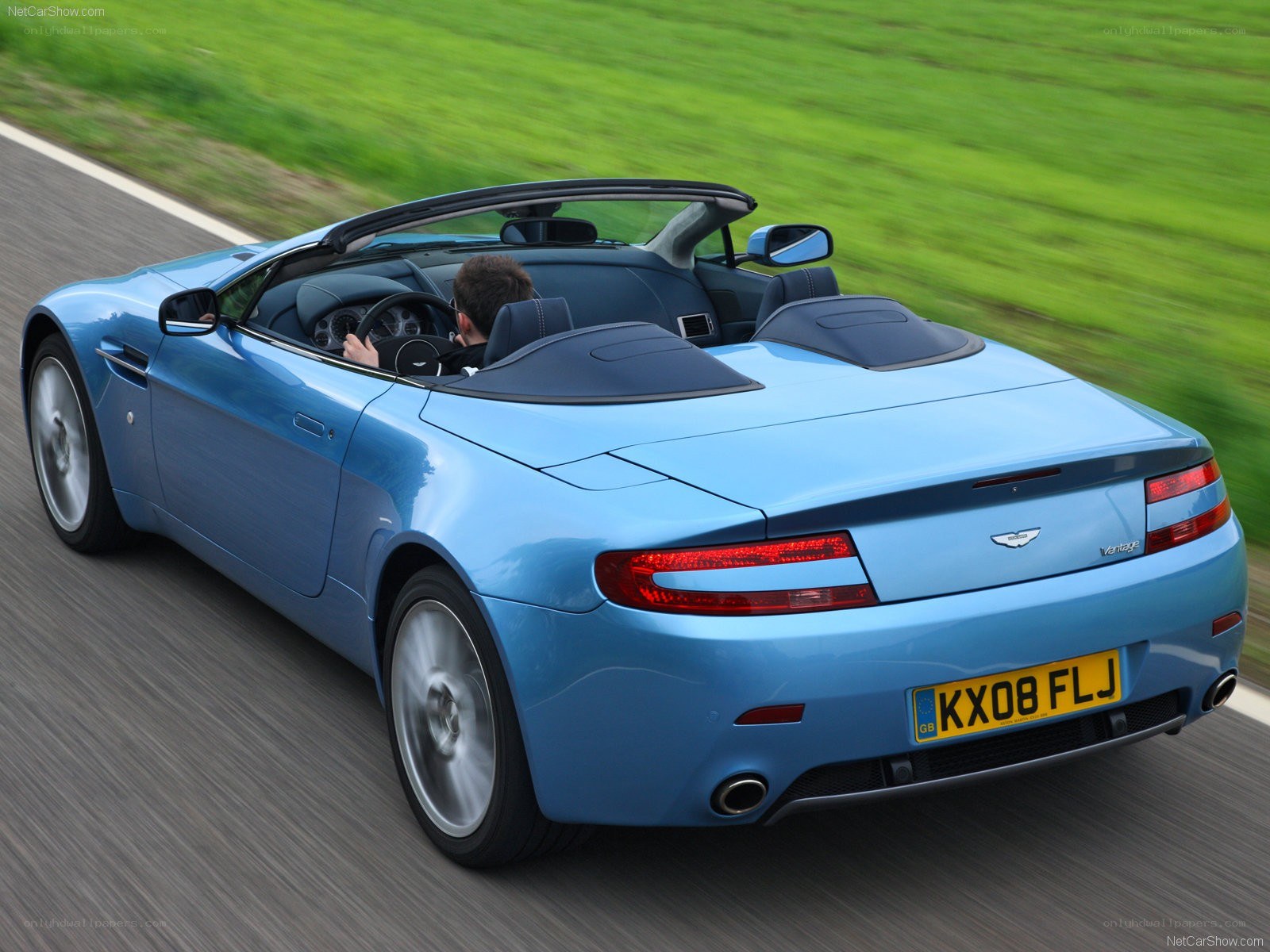 blue aston martin convertible driving