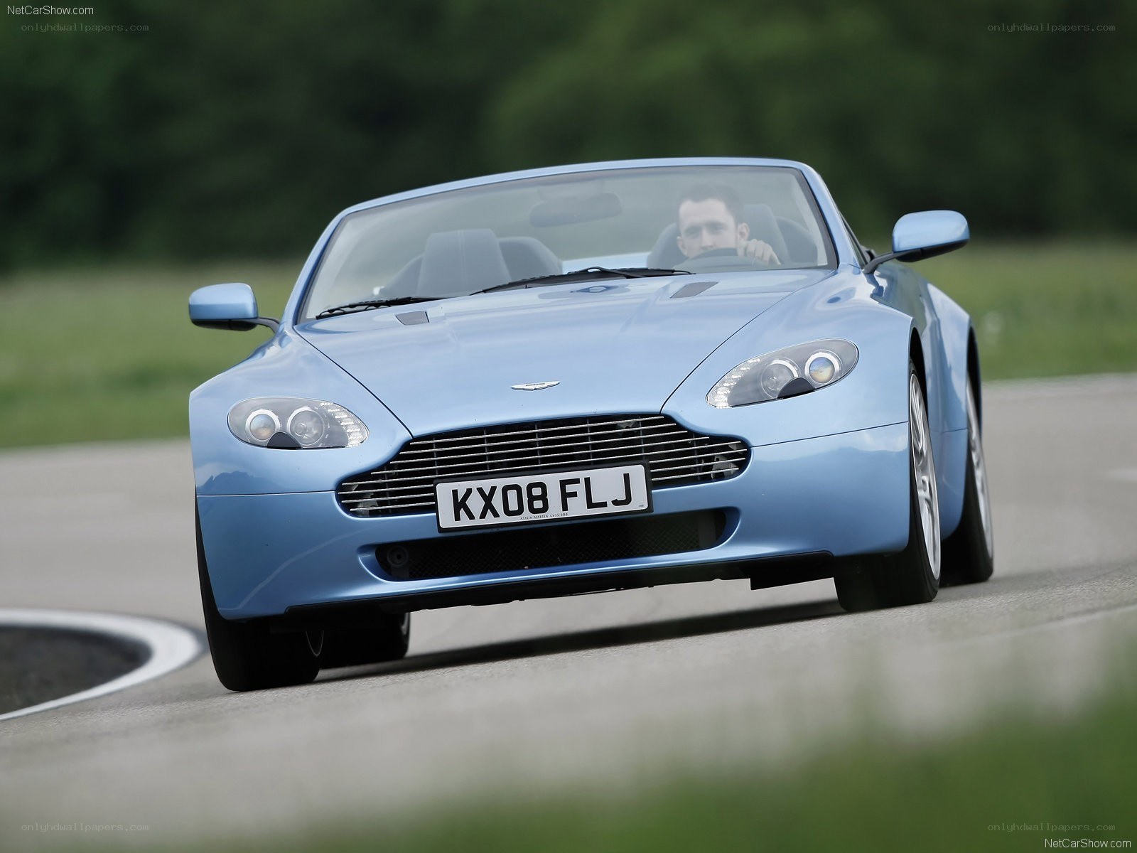 blue aston martin driving