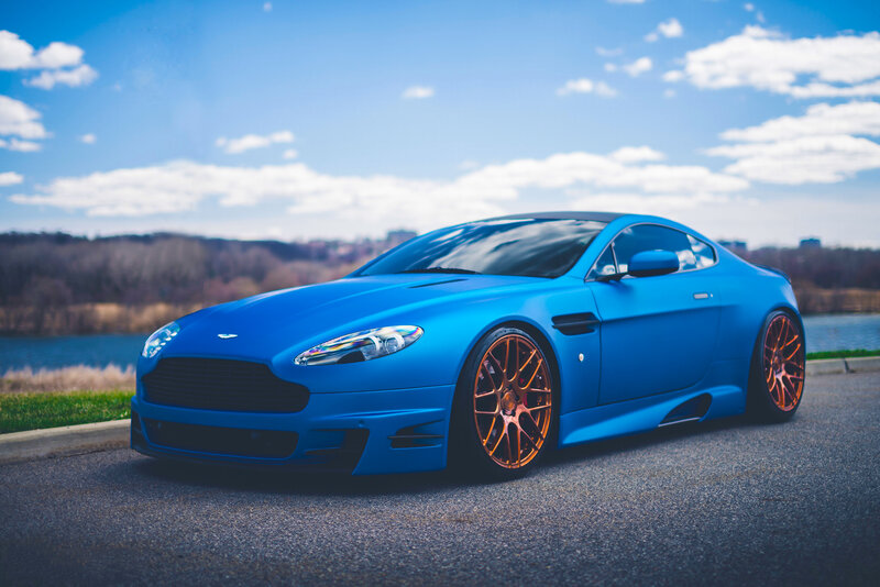 Blue Aston Martin on a scenic road
