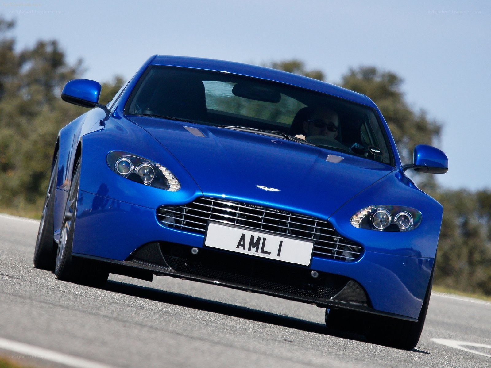blue aston martin on road