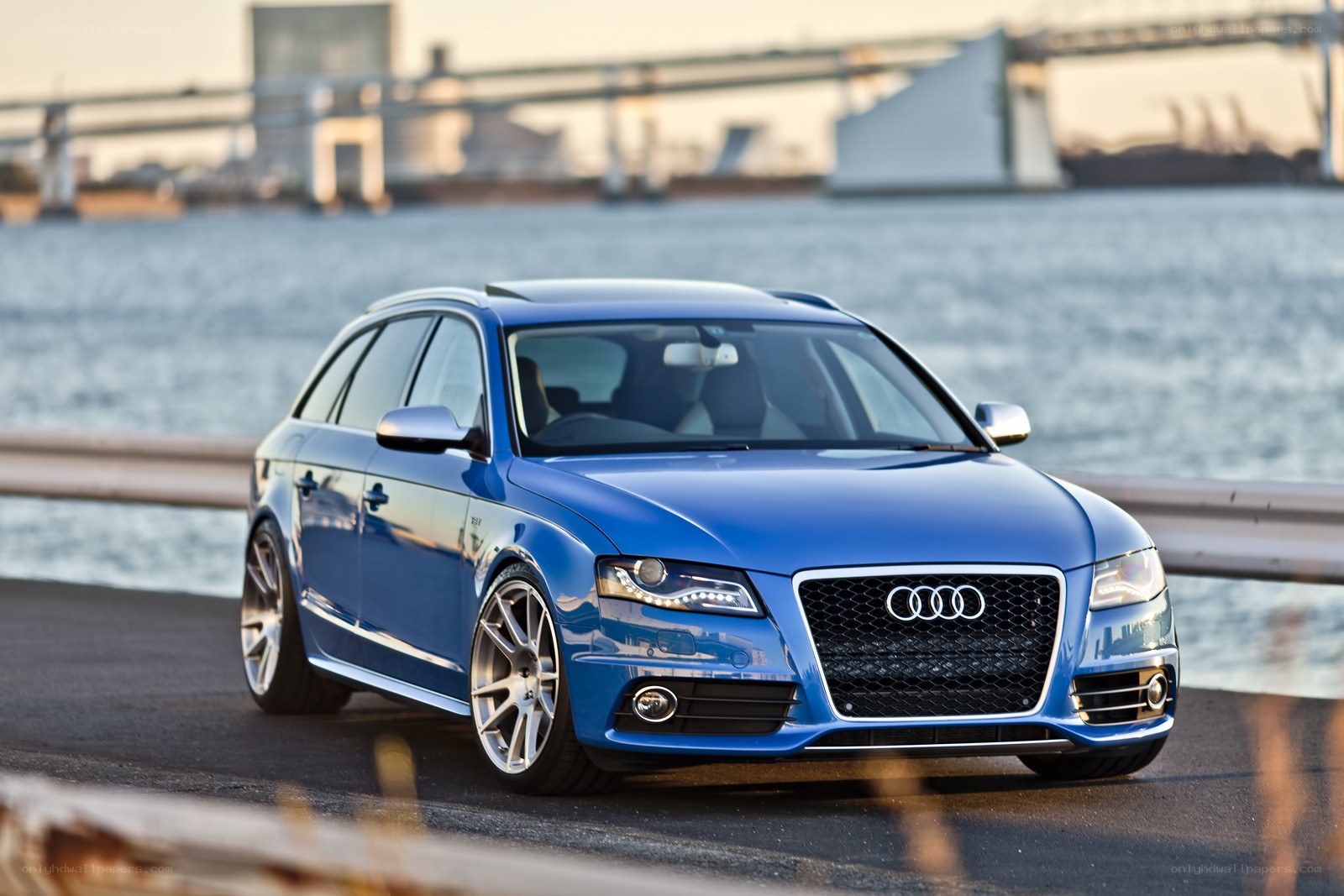 Blue Audi station wagon by water