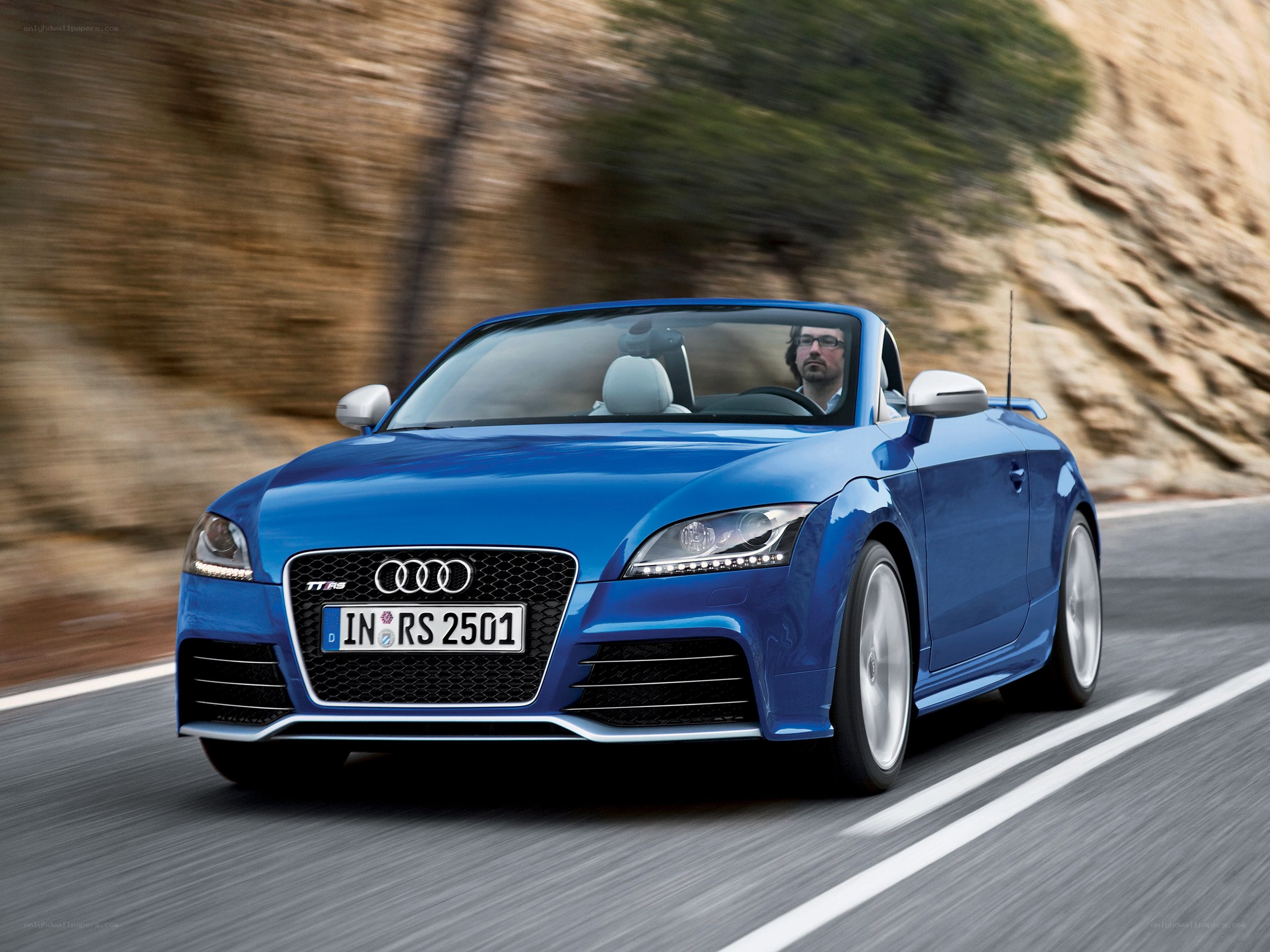 Blue Audi TT RS convertible in motion