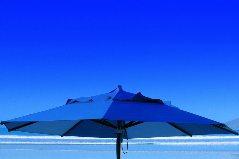 Blue beach umbrella at the shore