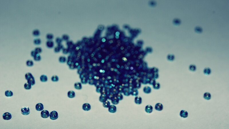 blue beads scattered on white surface
