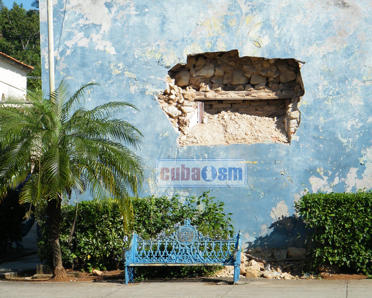 Blue bench with damaged wall
