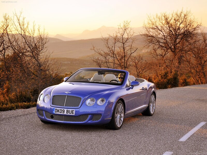 Blue Bentley convertible on a scenic road