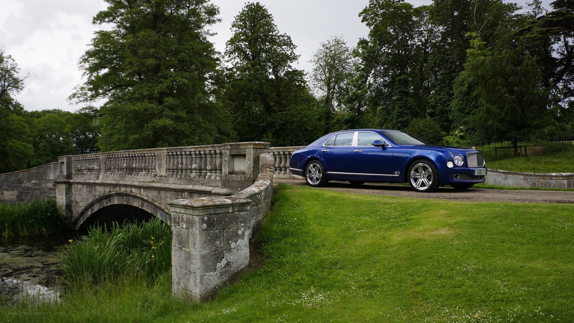 Blue Bentley on a stone bridge