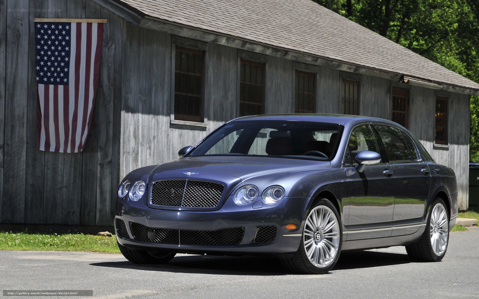 Blue Bentley parked by barn