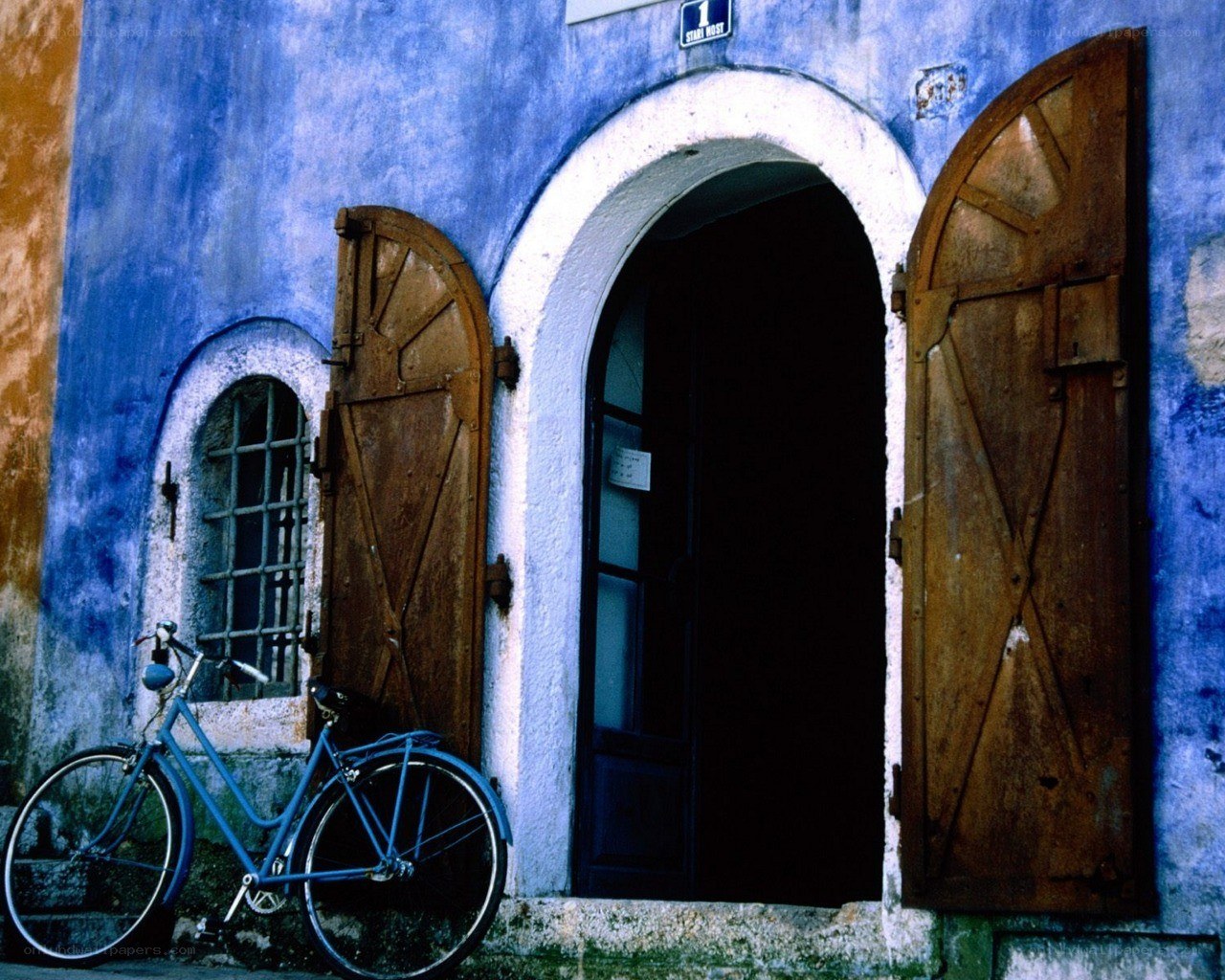Blue bicycle by a blue building
