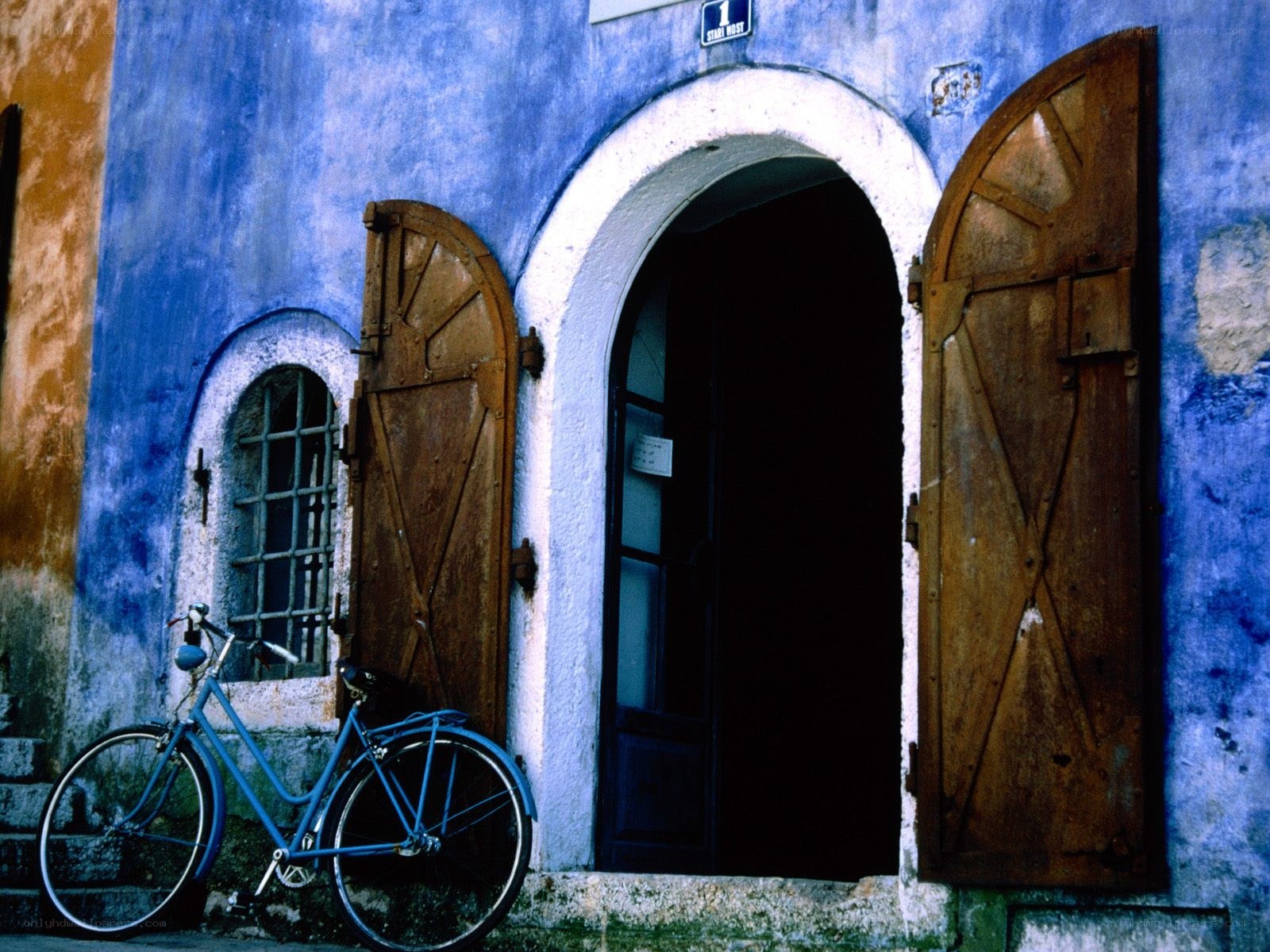 Blue bicycle by old building