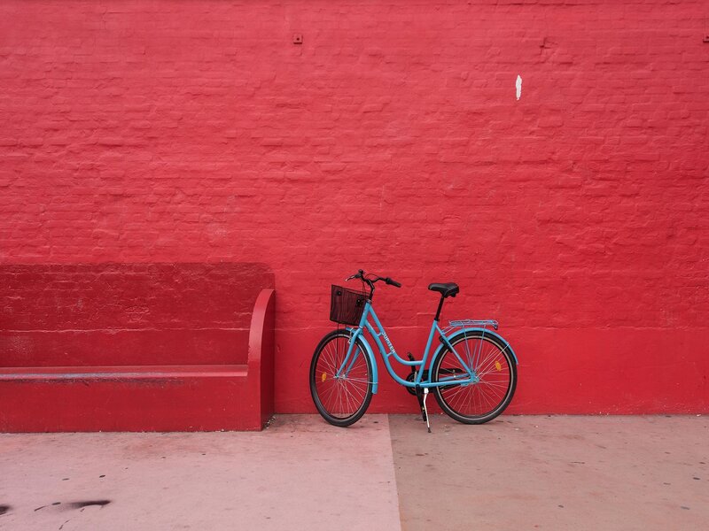 Blue bike against red wall