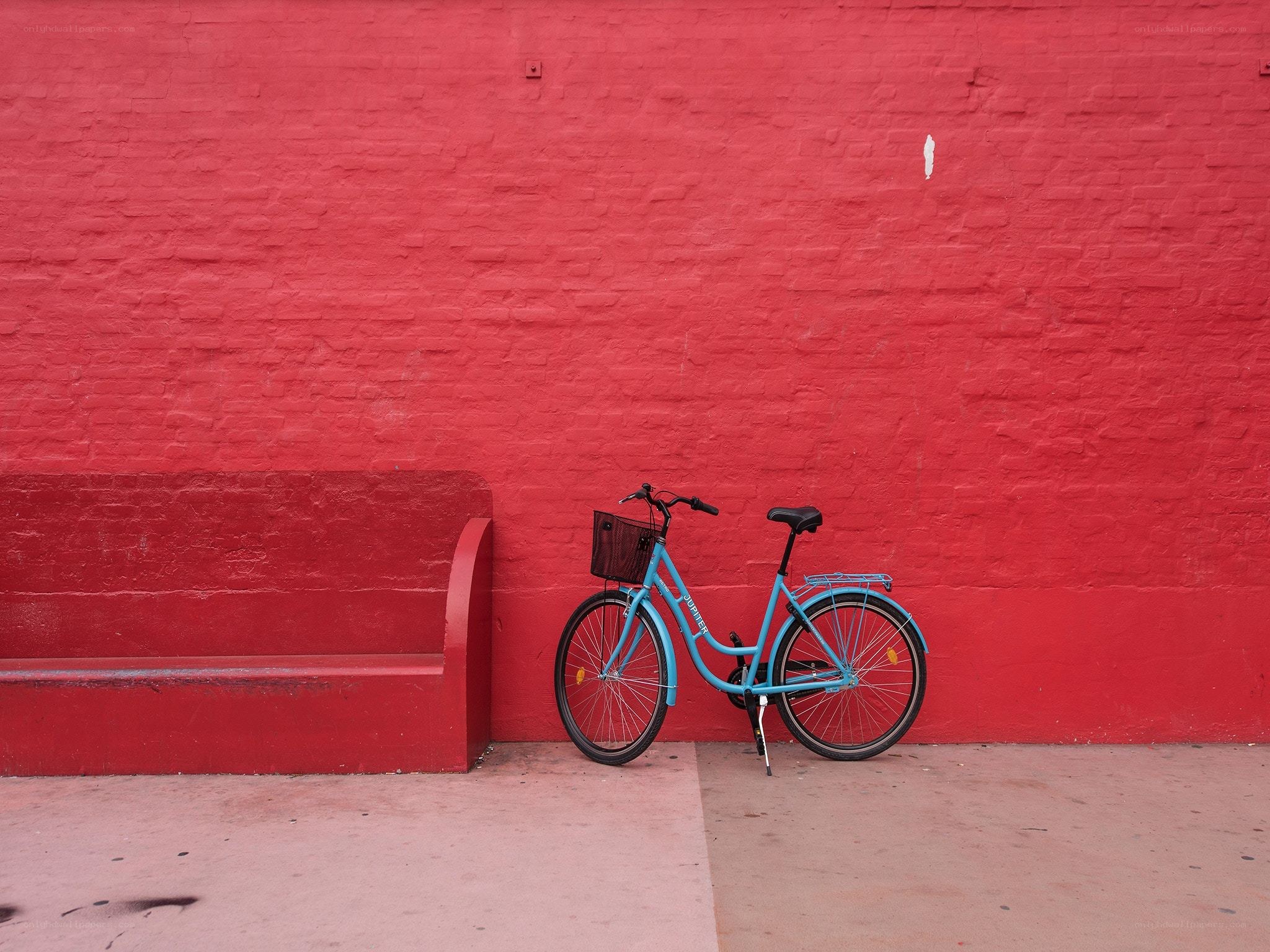 Blue bike against red wall