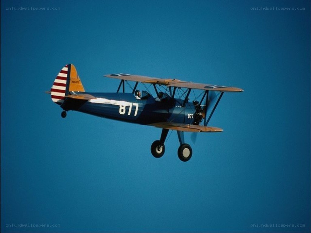 blue biplane in flight