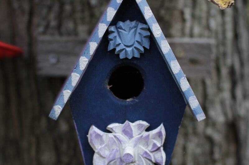 blue birdhouse with floral carvings