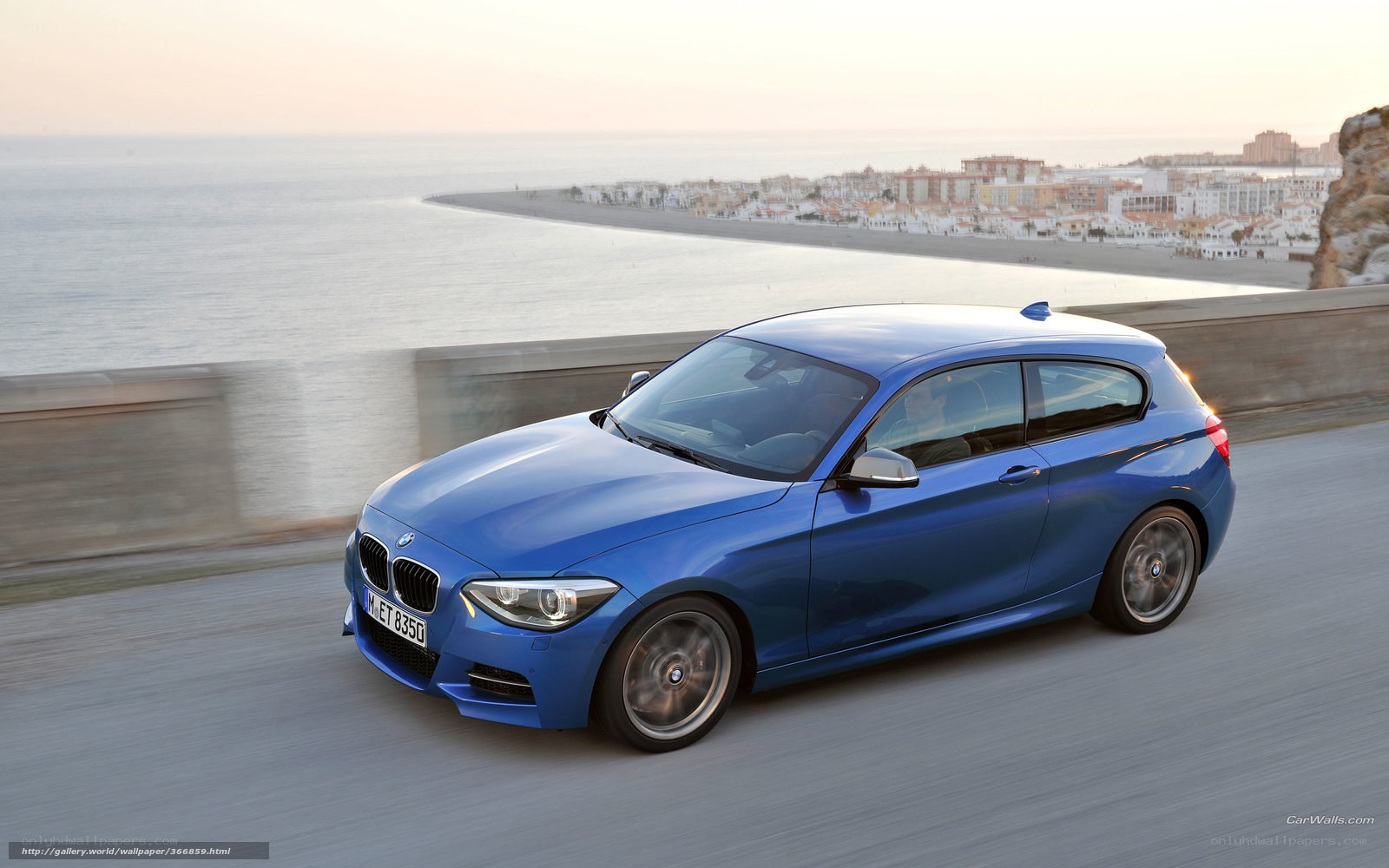 Blue BMW 1 Series on coastal road