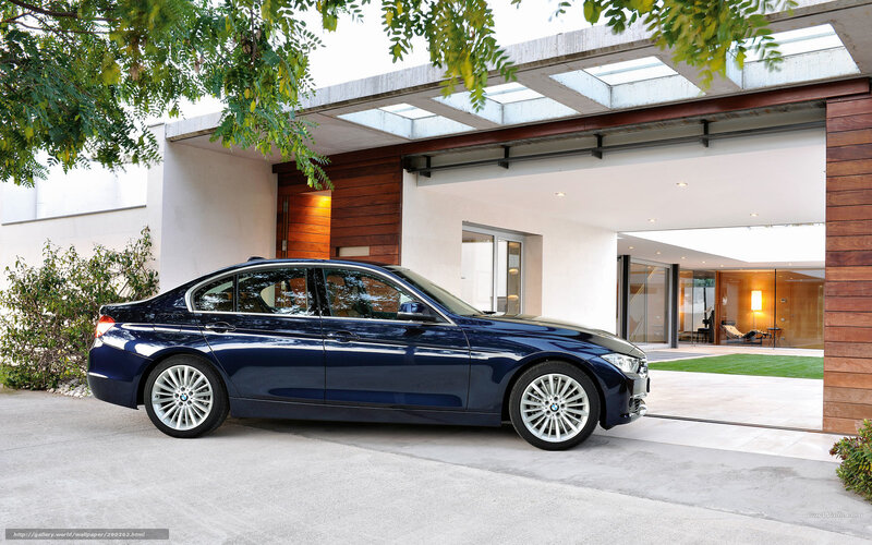 Blue BMW 3 Series parked outside modern house