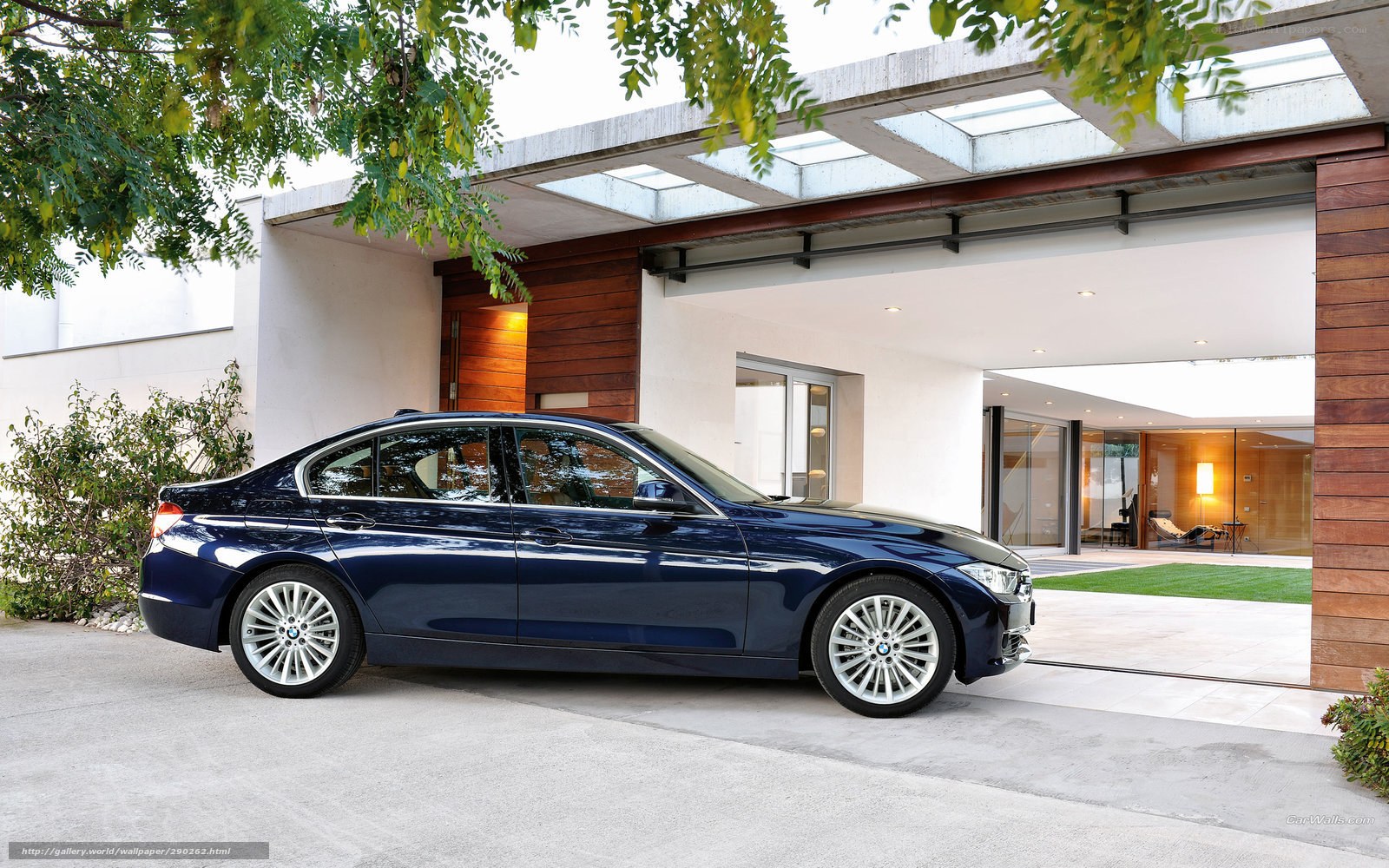 Blue BMW 3 Series parked outside modern house