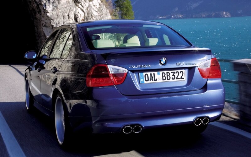 Blue BMW Alpina on a lakeside road