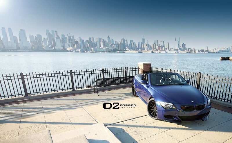 Blue BMW convertible by city skyline